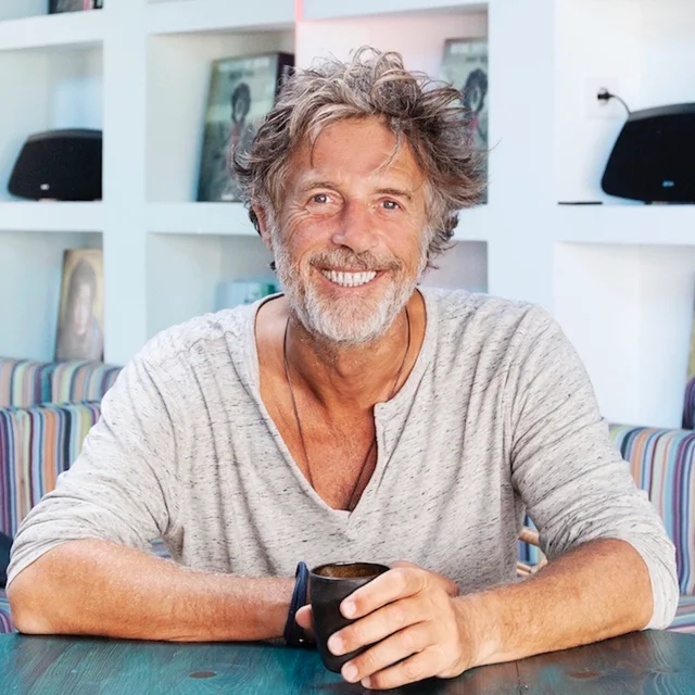 Luc Carpentier, smiling, with a cup of coffee